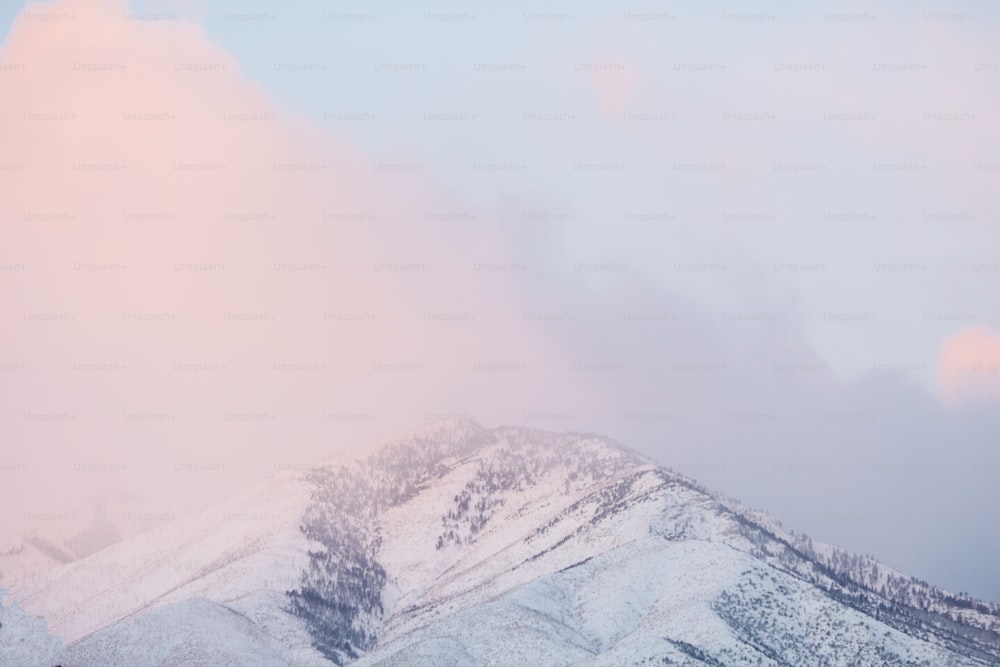 a mountain covered in snow under a cloudy sky