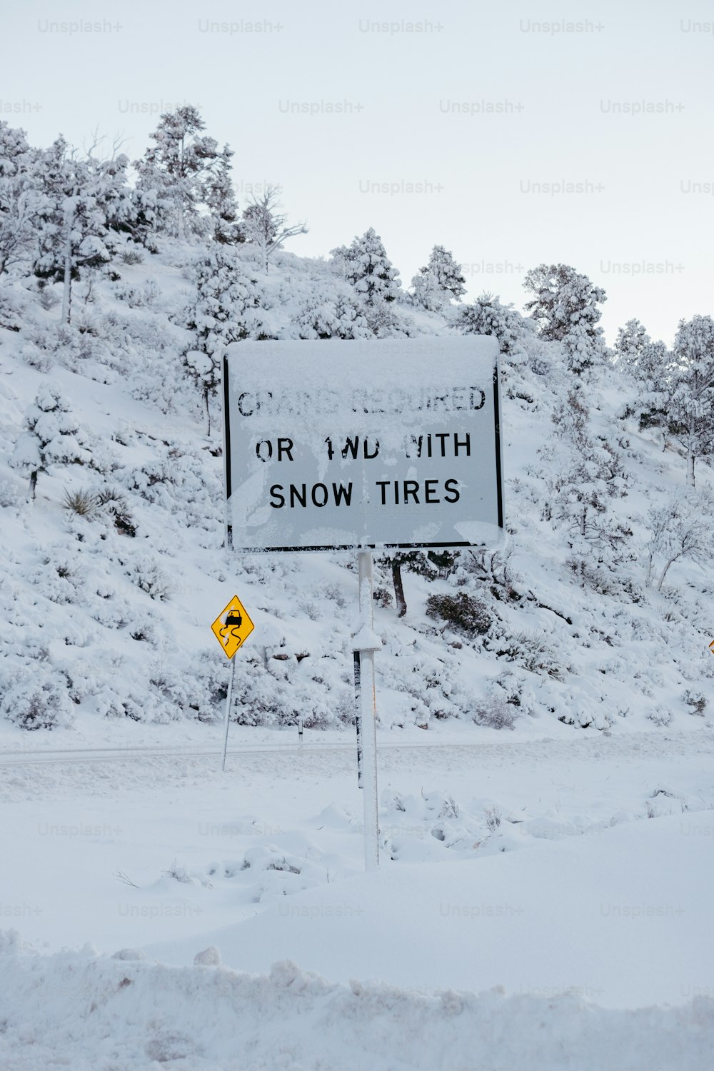 Ein Schild, das sich an der Seite eines verschneiten Hügels befindet