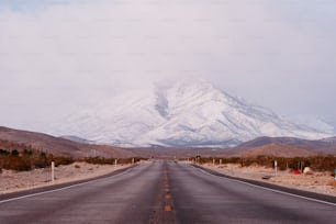 Una strada vuota con una montagna innevata sullo sfondo