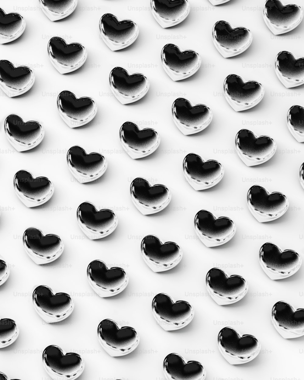 Un grupo de corazones blancos y negros sobre una superficie blanca