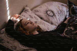 Una donna sdraiata su un letto con gli occhi chiusi