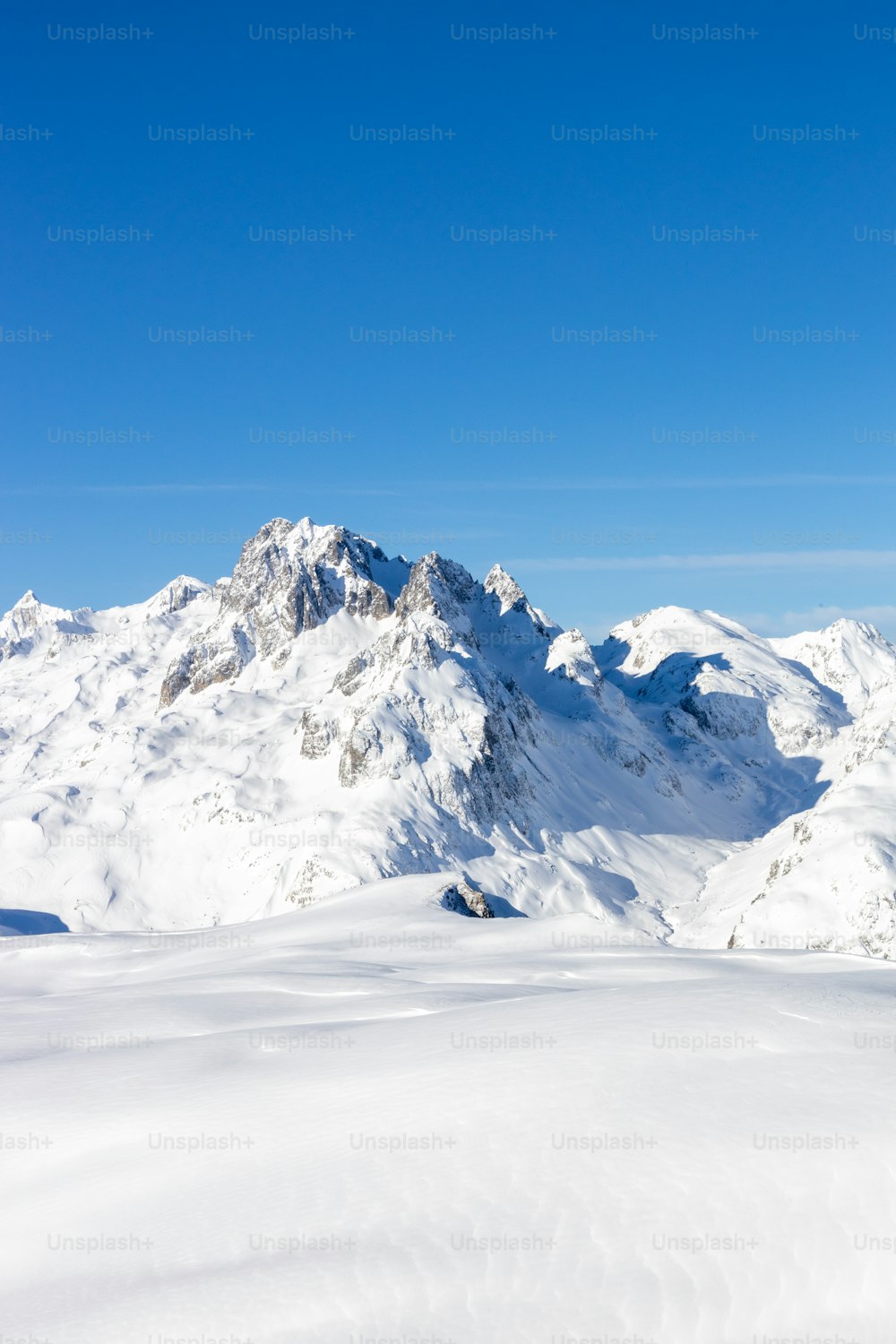 Un hombre montando esquís en la cima de una pendiente cubierta de nieve