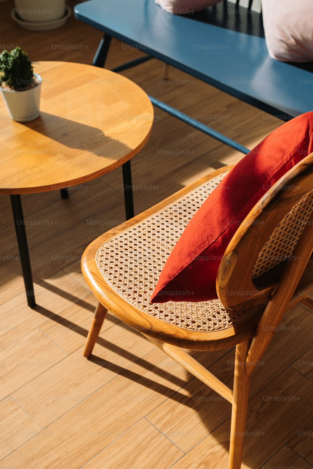 a wooden chair with a red pillow on top of it