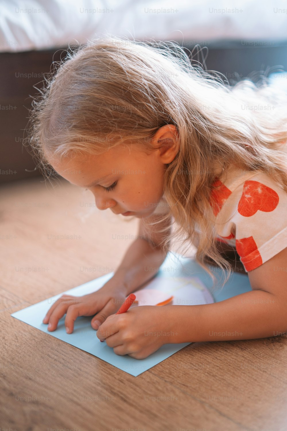 a little girl is writing on a piece of paper