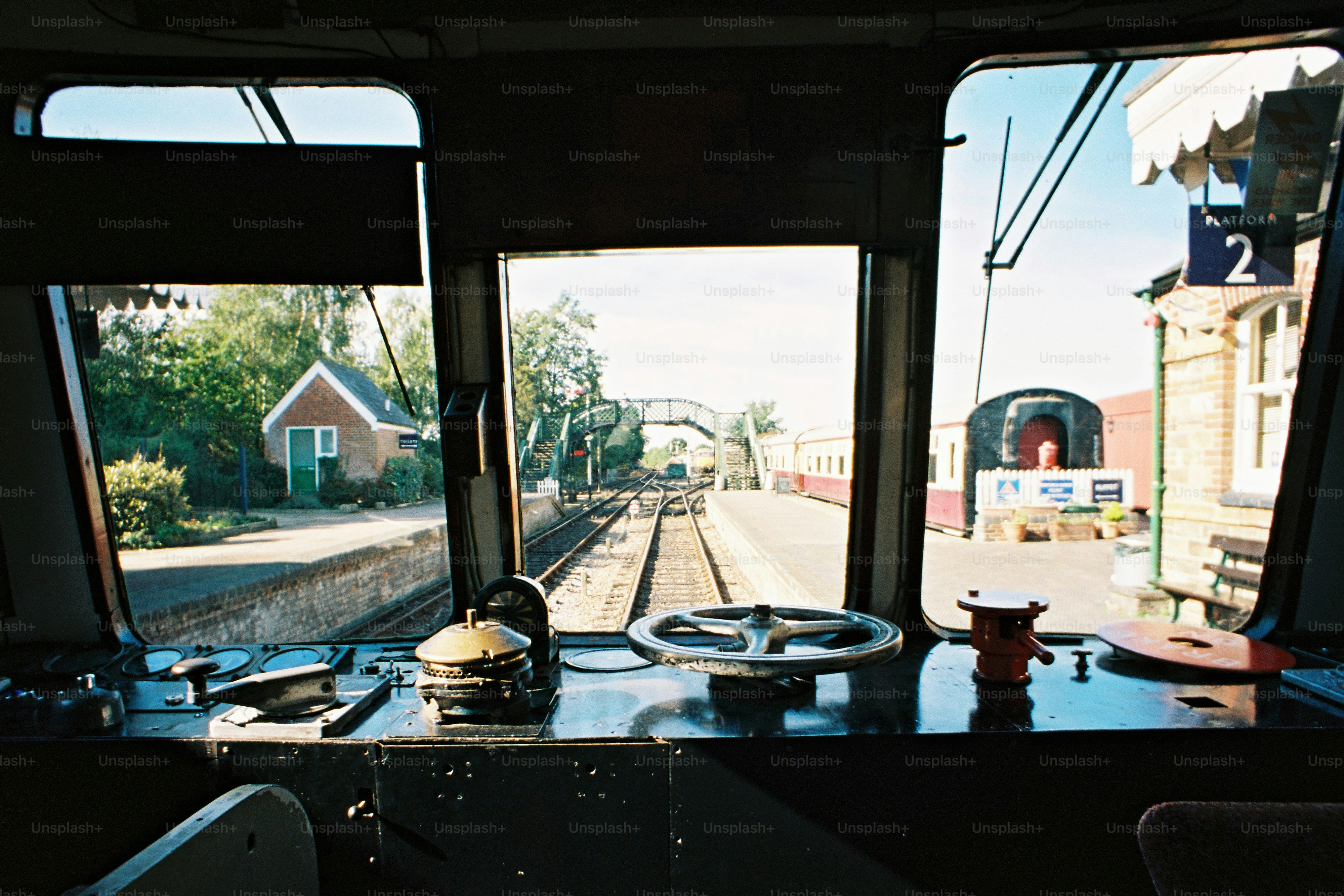 A train driver’s view of a vintage train pulling up to a station platform. Shot on film.