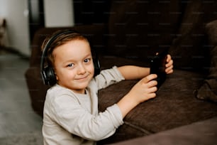 a young boy with headphones on sitting on a couch