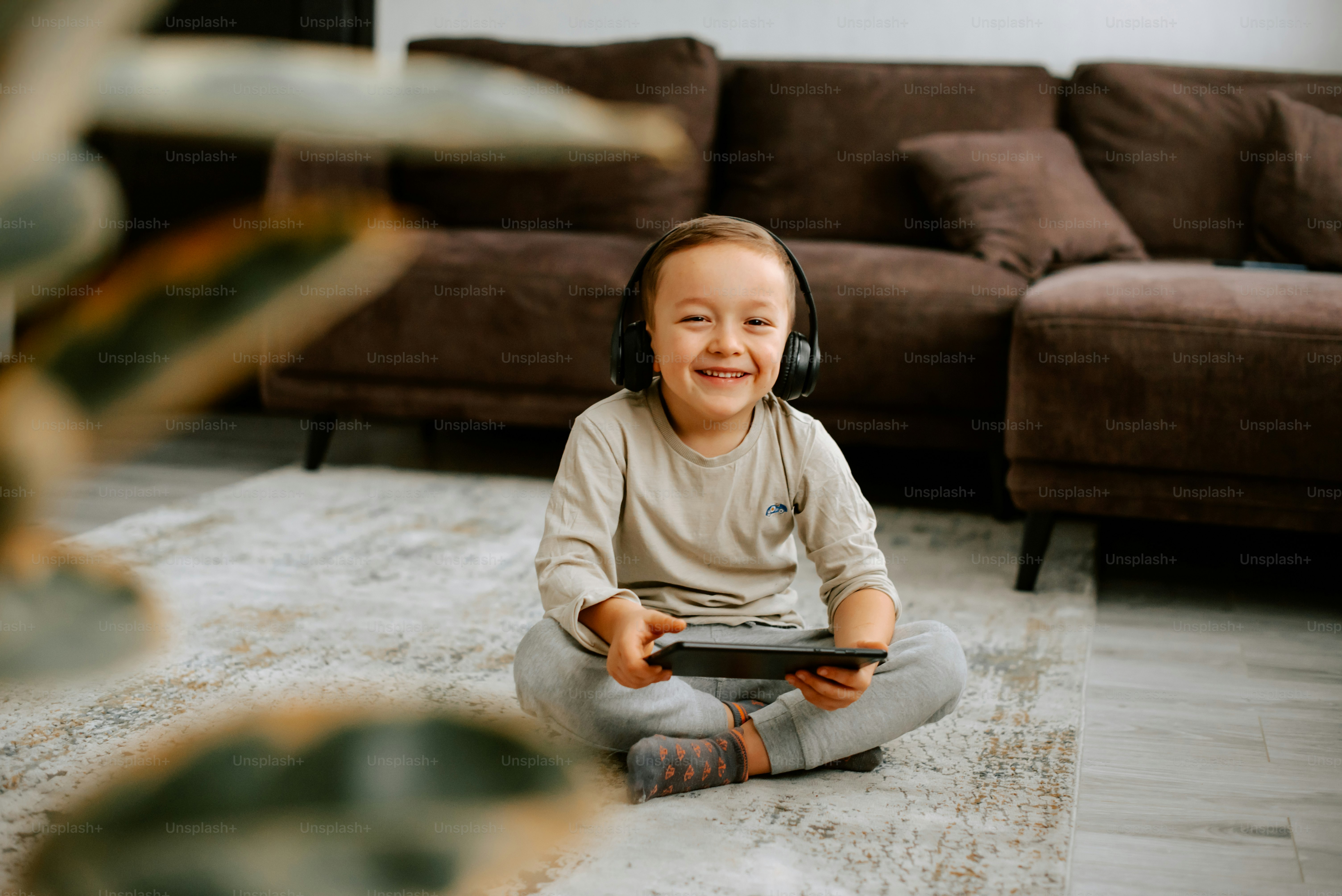 a little girl sitting on the floor with headphones on