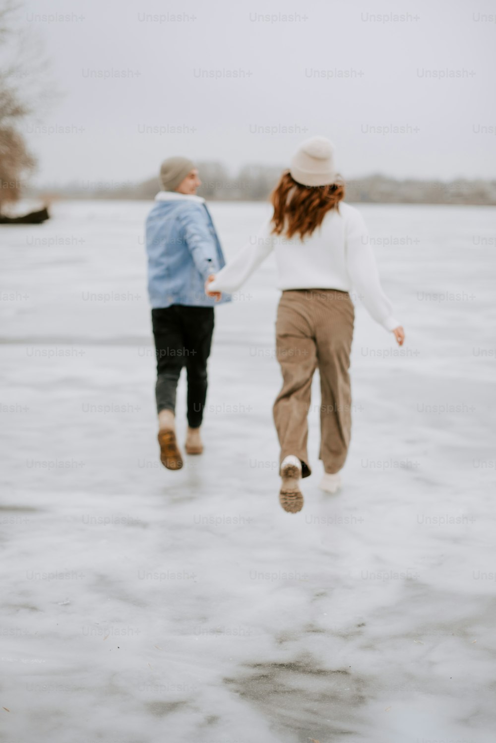 手をつないで凍った湖を渡る二人
