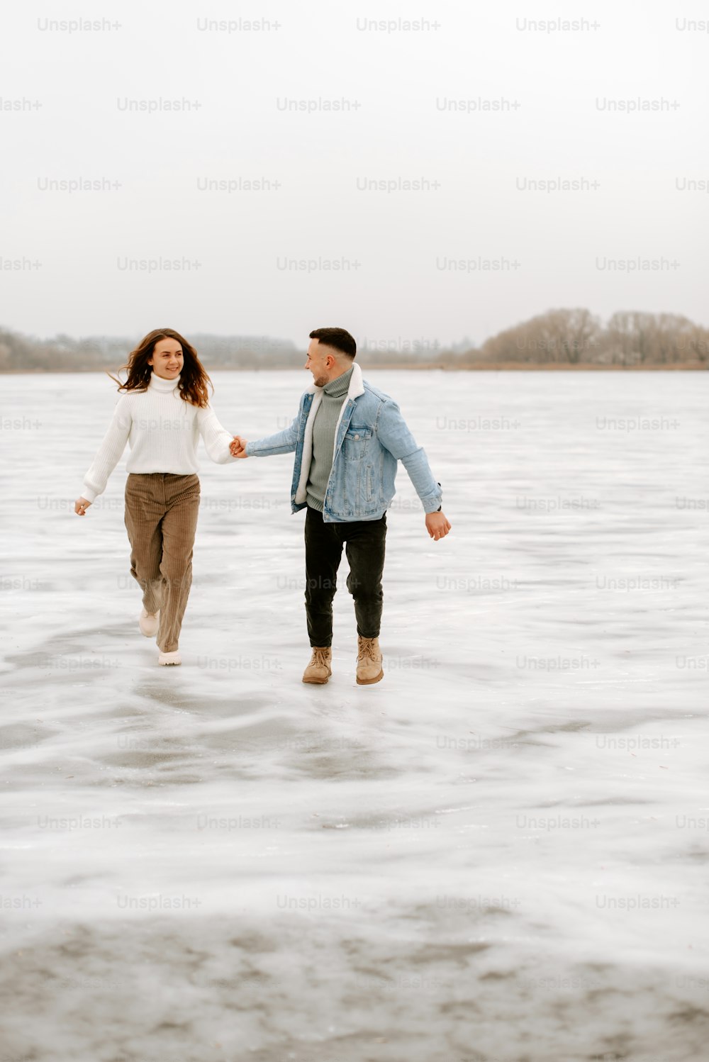 a man and a woman are walking in the water
