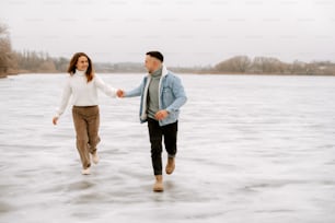 a man and a woman are walking in the water