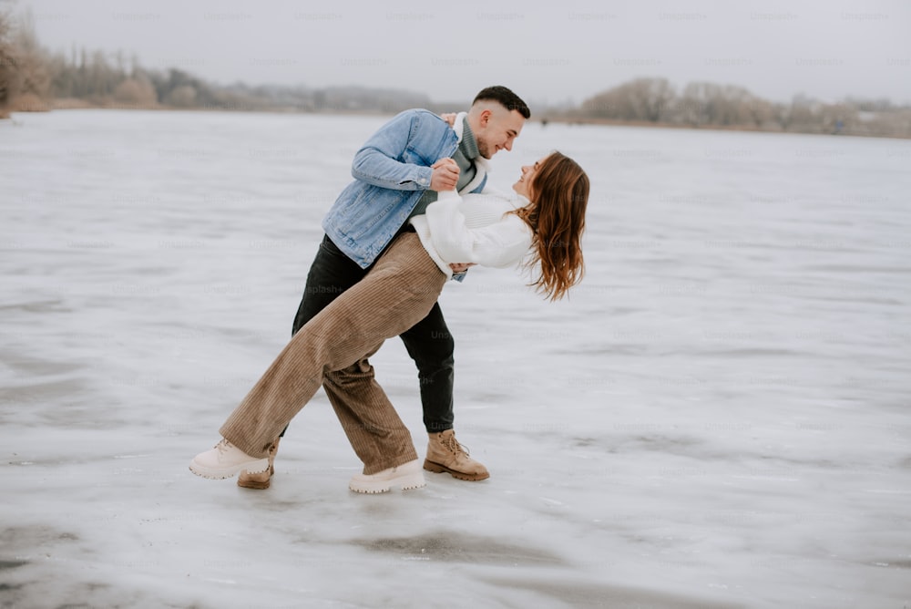 um homem e uma mulher dançando em um lago congelado