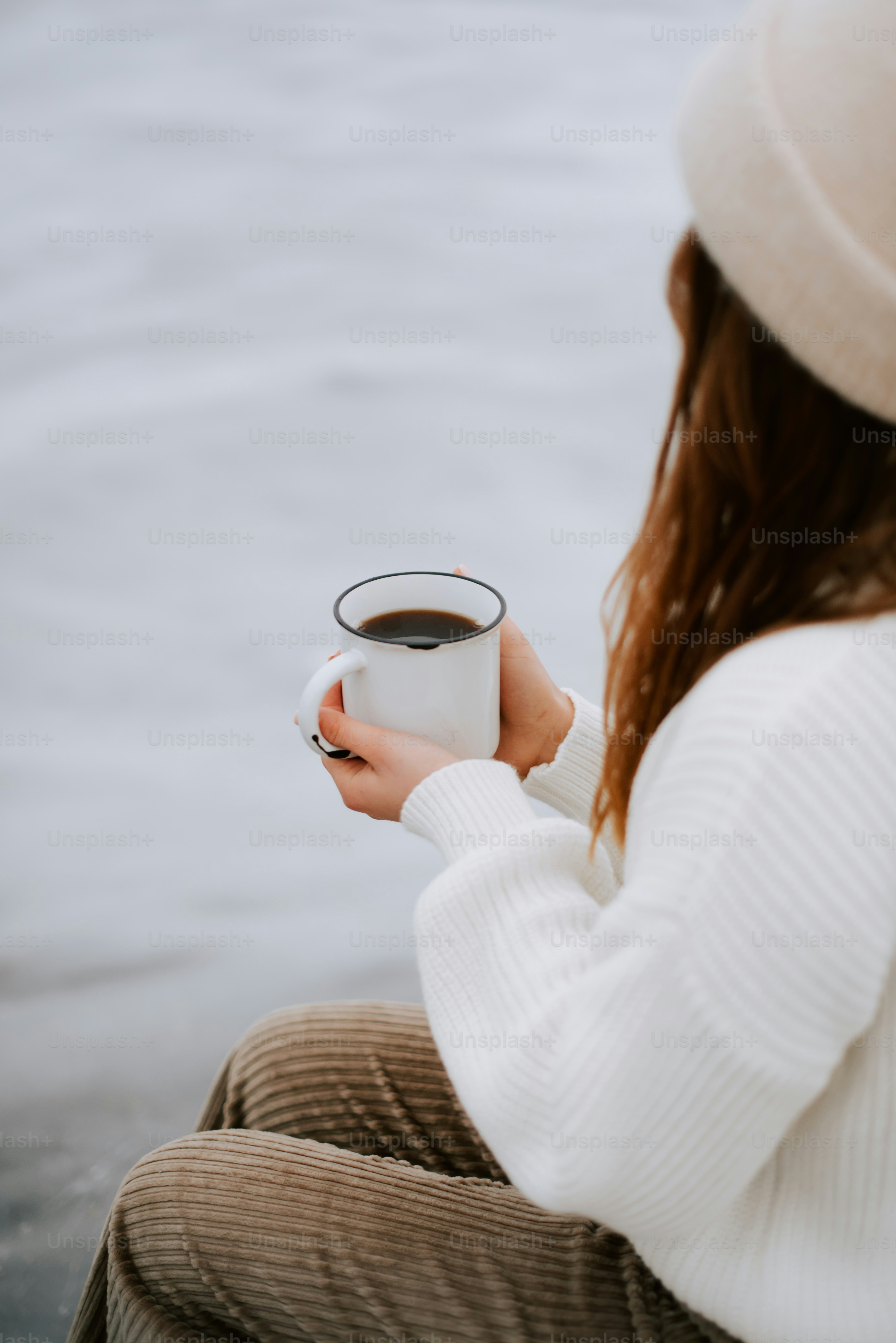 a woman holding a cup of coffee in her hands