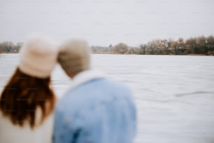 a man and a woman are looking at the water