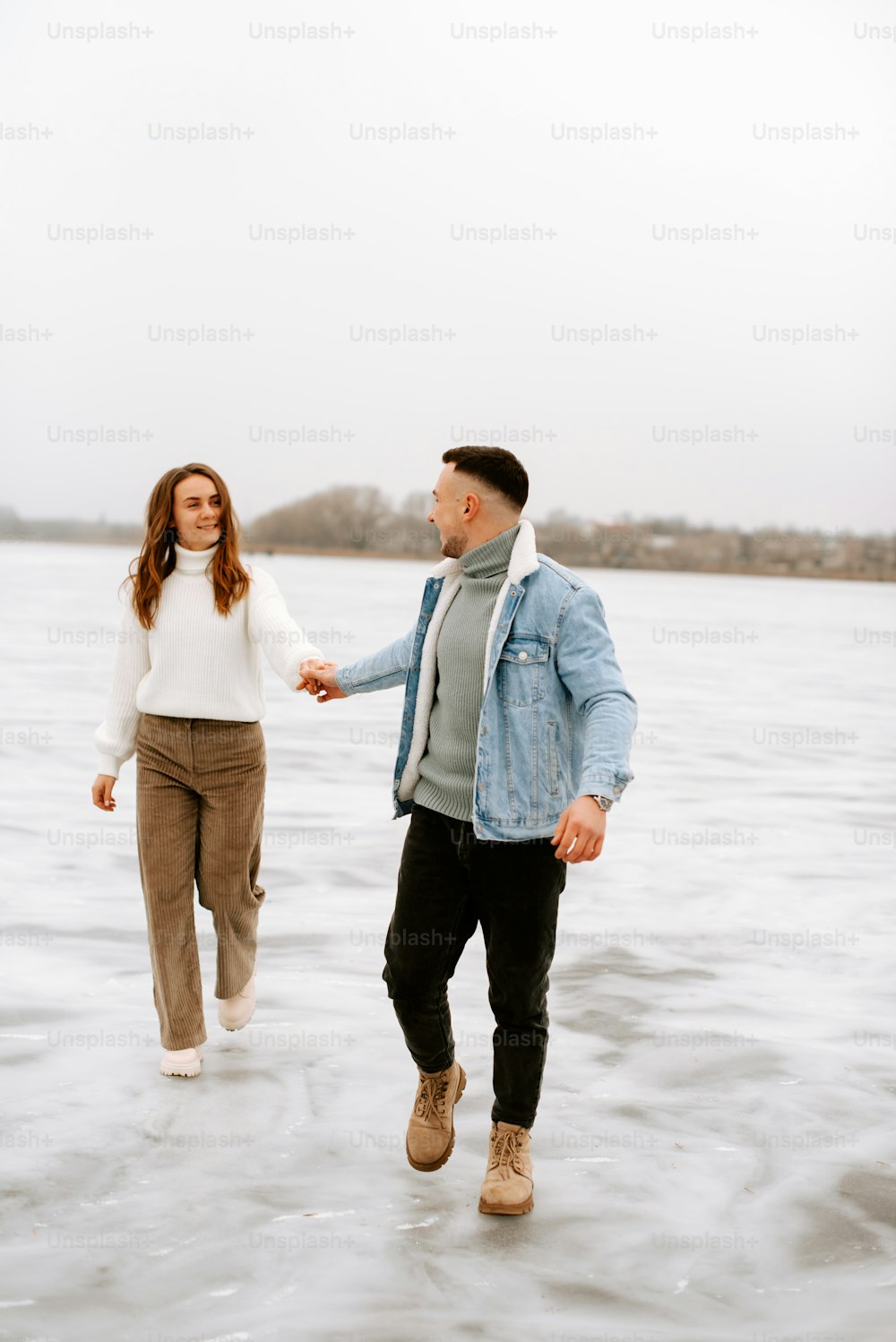 a man and a woman are walking in the water