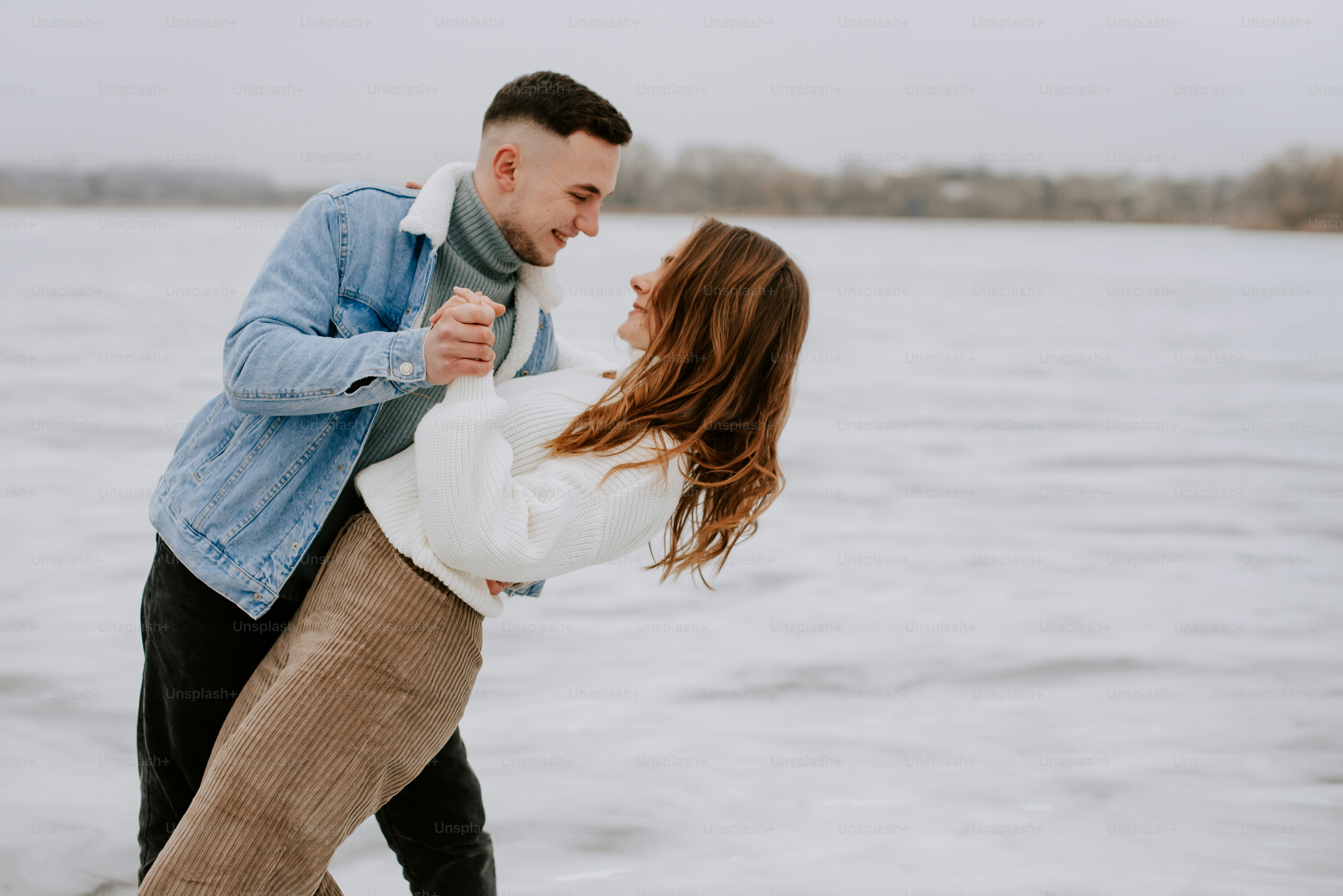 a man and a woman standing next to a body of water