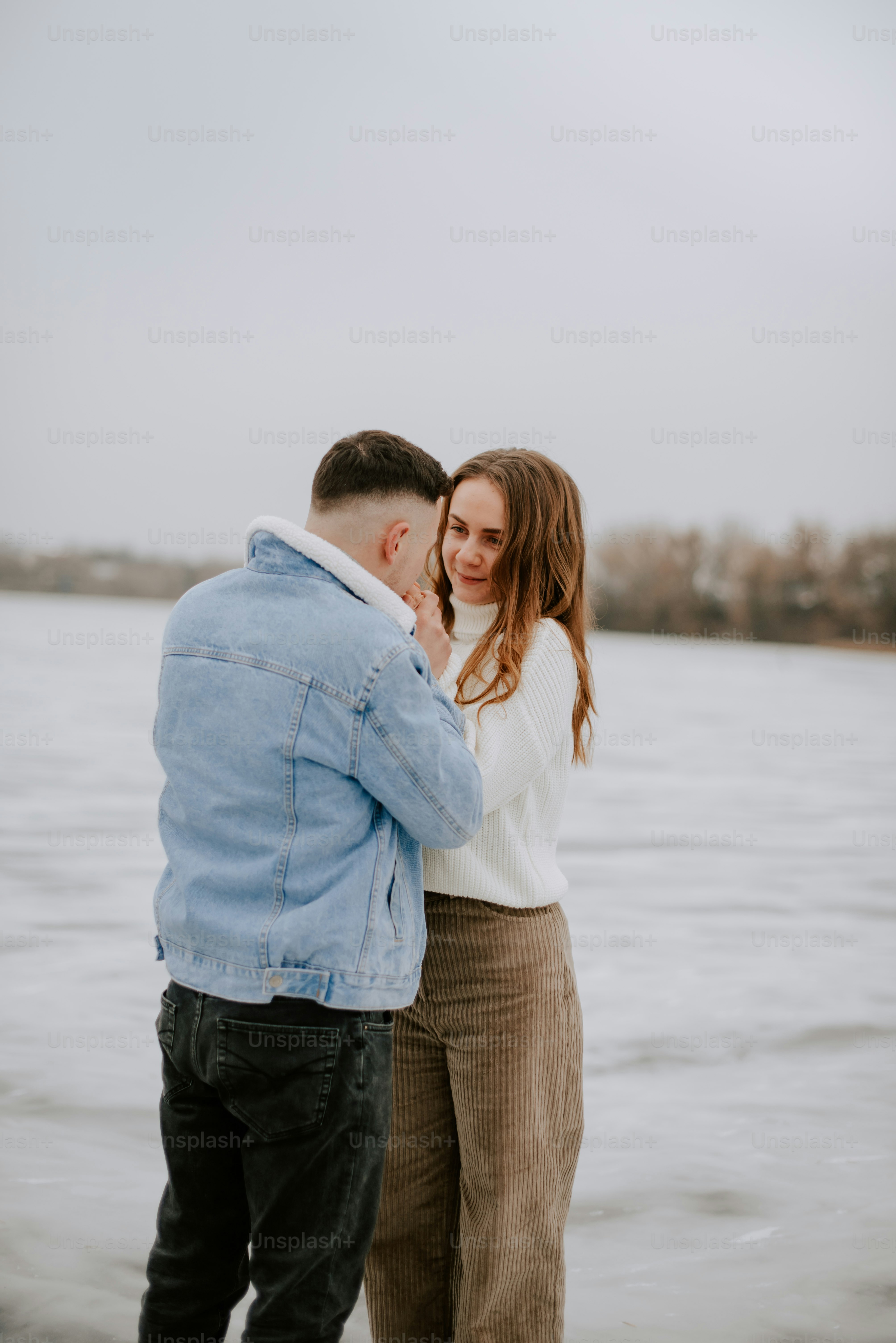 a man and woman standing next to a body of water