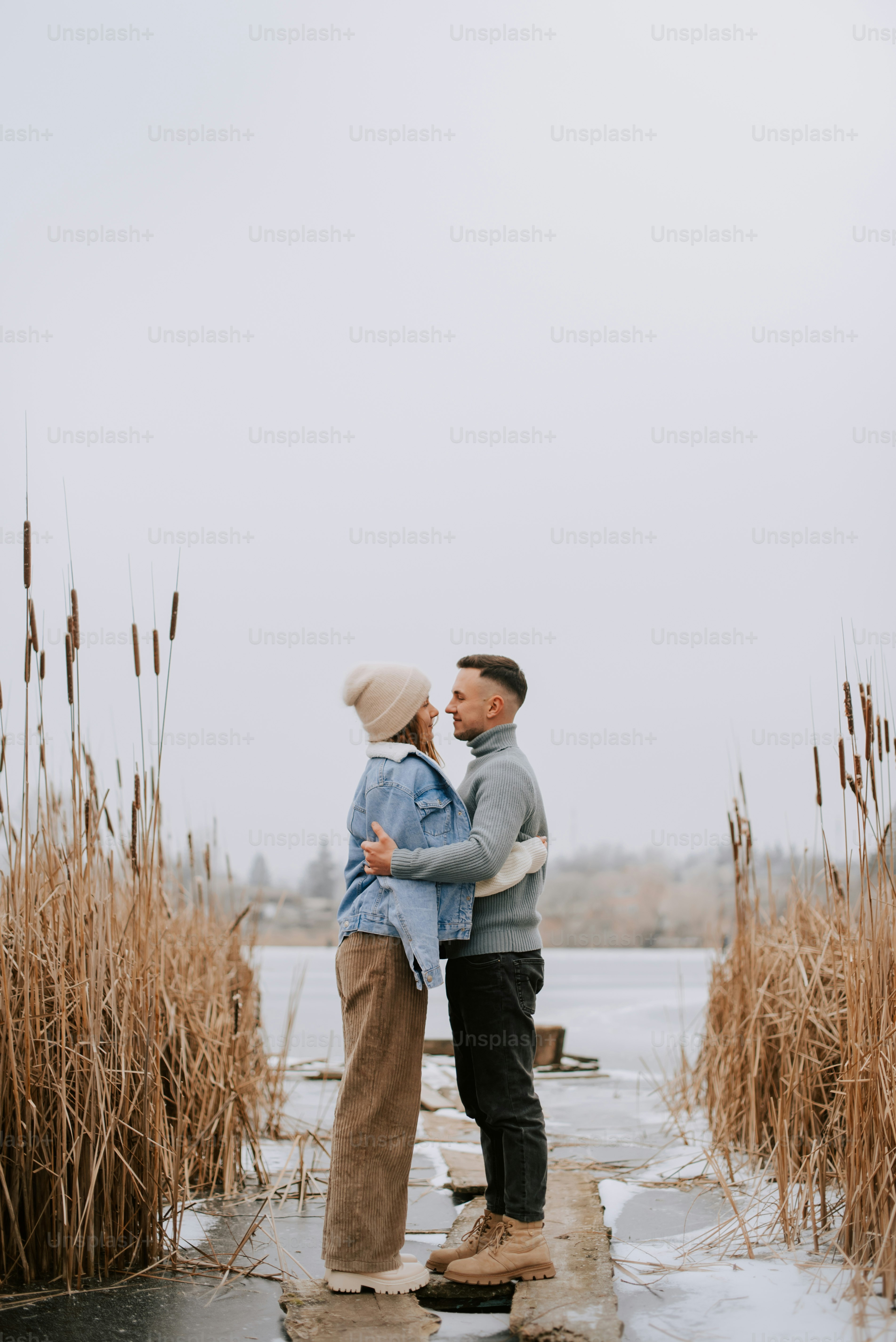 a man and a woman kissing on a dock