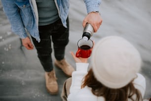 Ein Mann gießt einer Frau eine Tasse Kaffee in die Hand