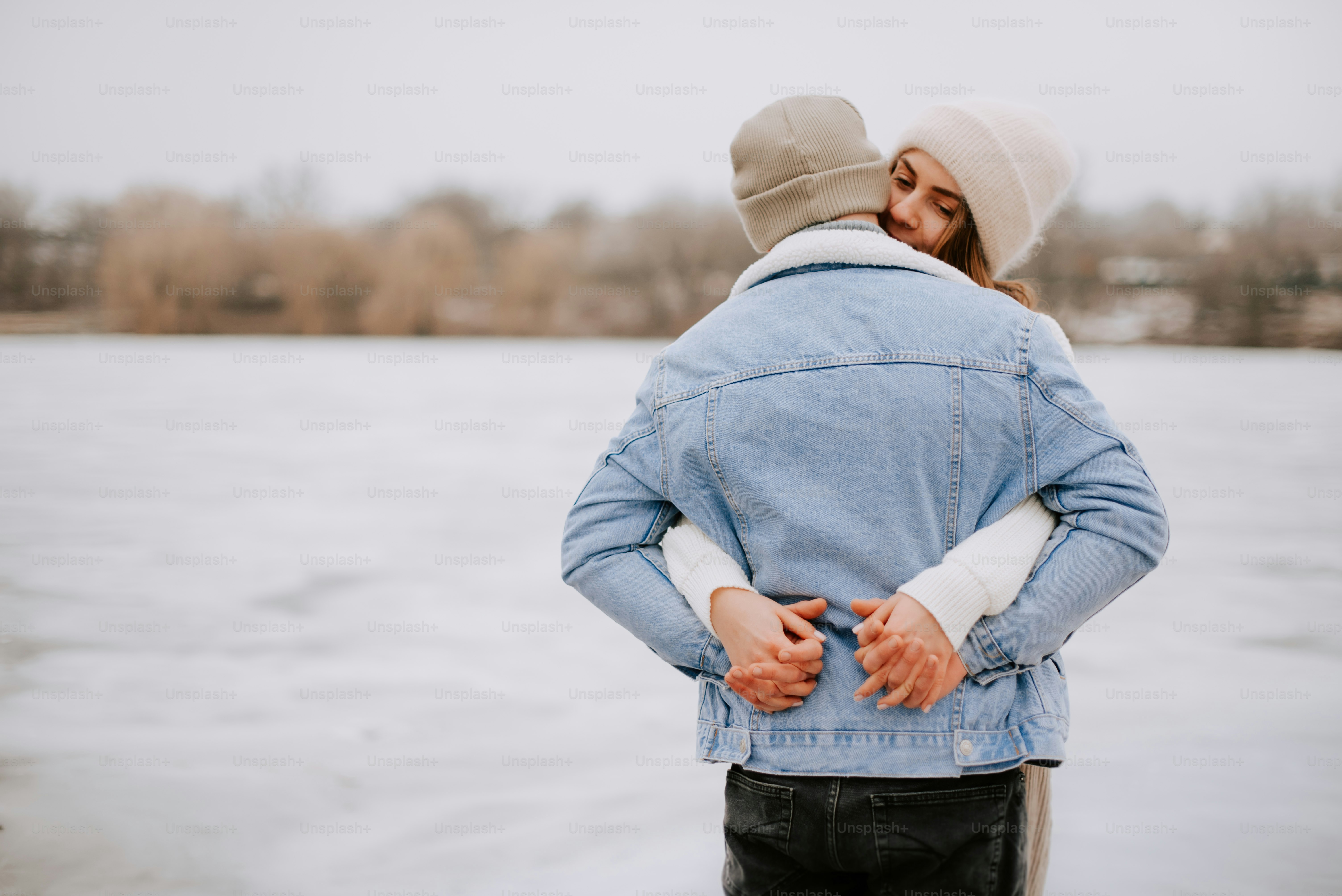 a man and a woman standing in front of a body of water
