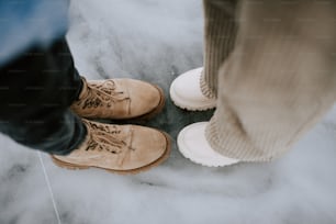 two people standing next to each other wearing boots