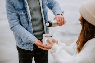 a man pouring something into a woman's cup