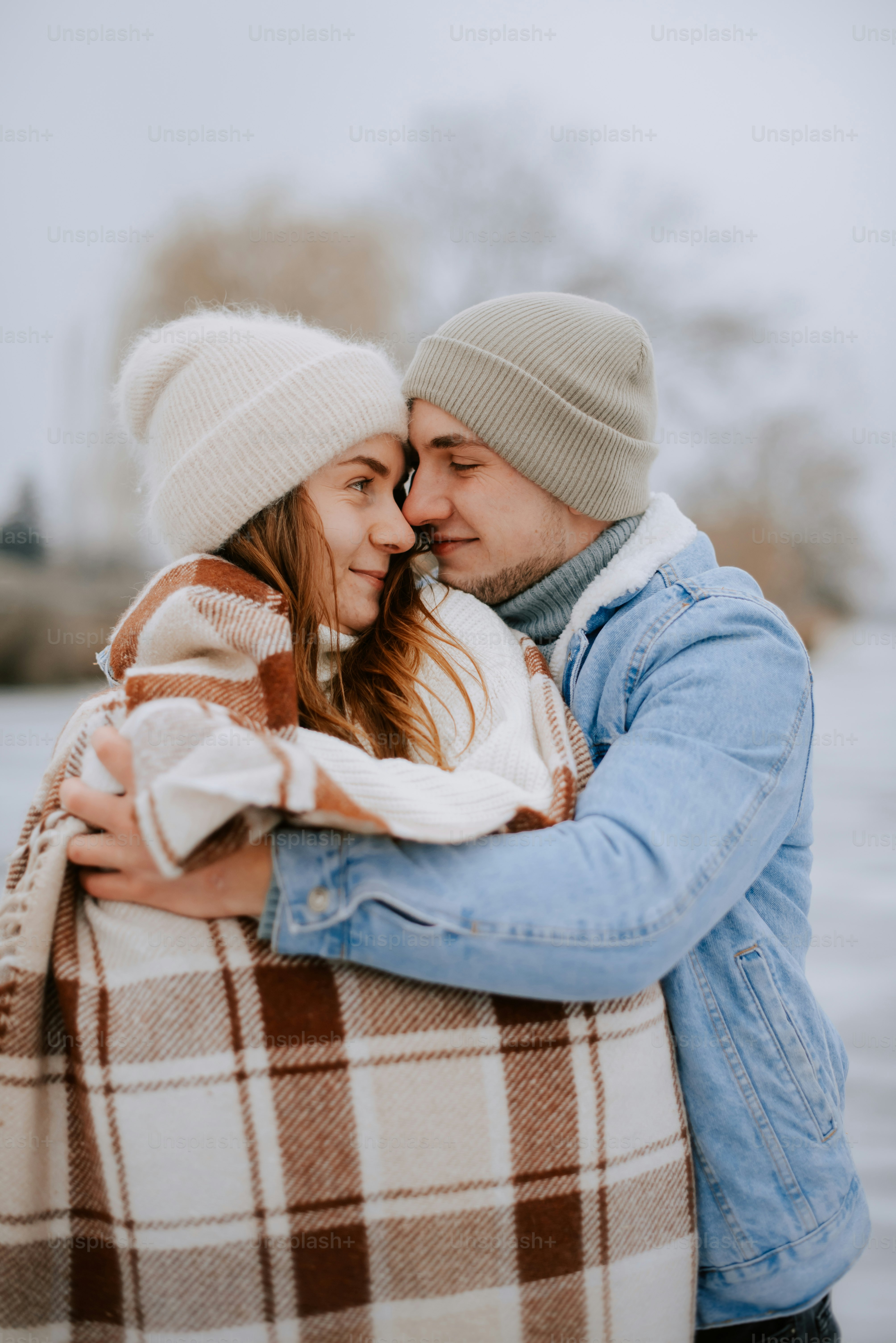 a man and woman hugging each other in front of a body of water