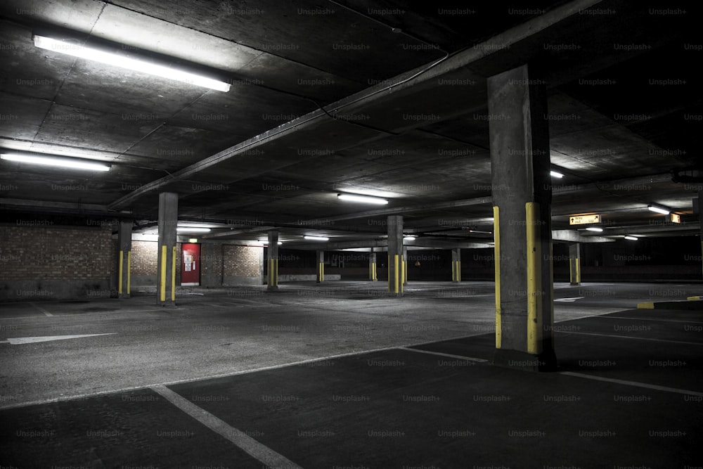 an empty parking garage with a red door