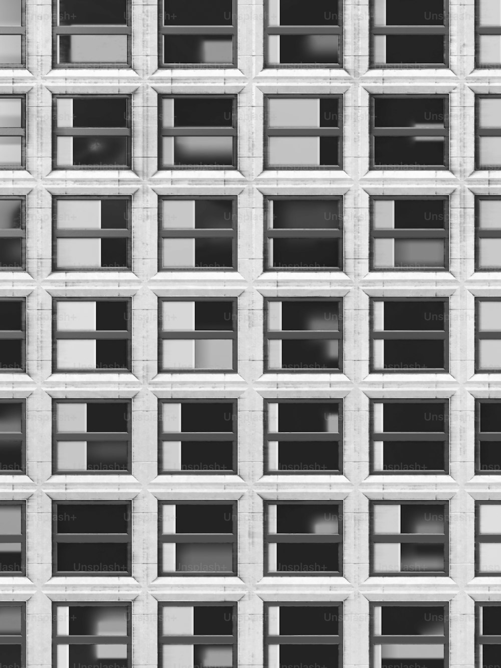 une photo en noir et blanc des fenêtres d’un bâtiment