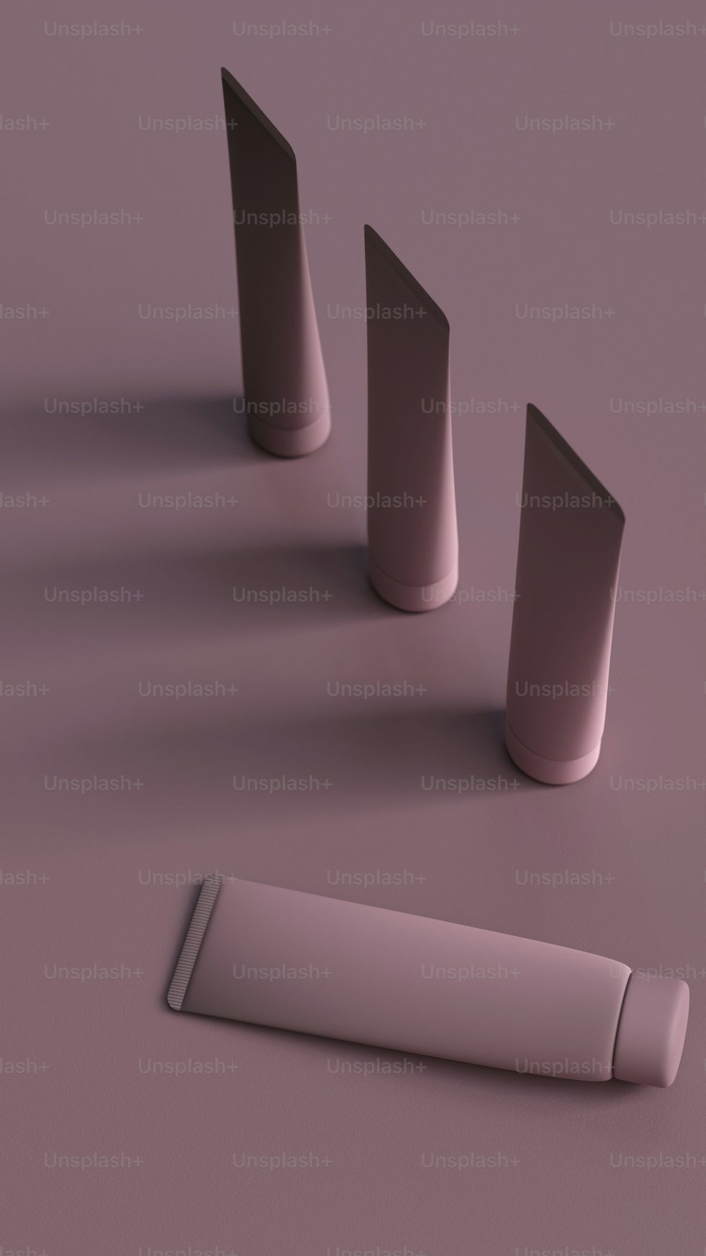 Eine Gruppe von drei zylindrischen Objekten auf einer violetten Oberfläche