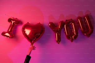 a person holding a heart shaped balloon in front of the word joy