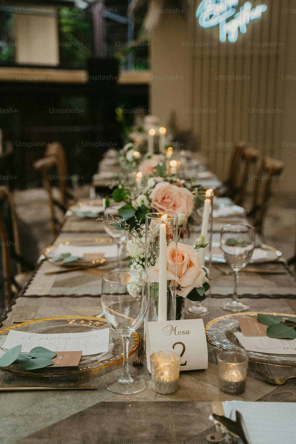 Una mesa larga está puesta con velas y flores