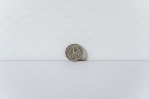 une pièce de monnaie posée sur une surface blanche