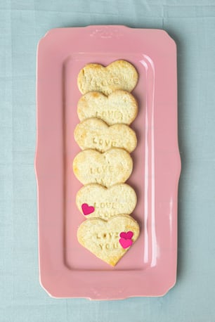 a pink plate topped with heart shaped cookies