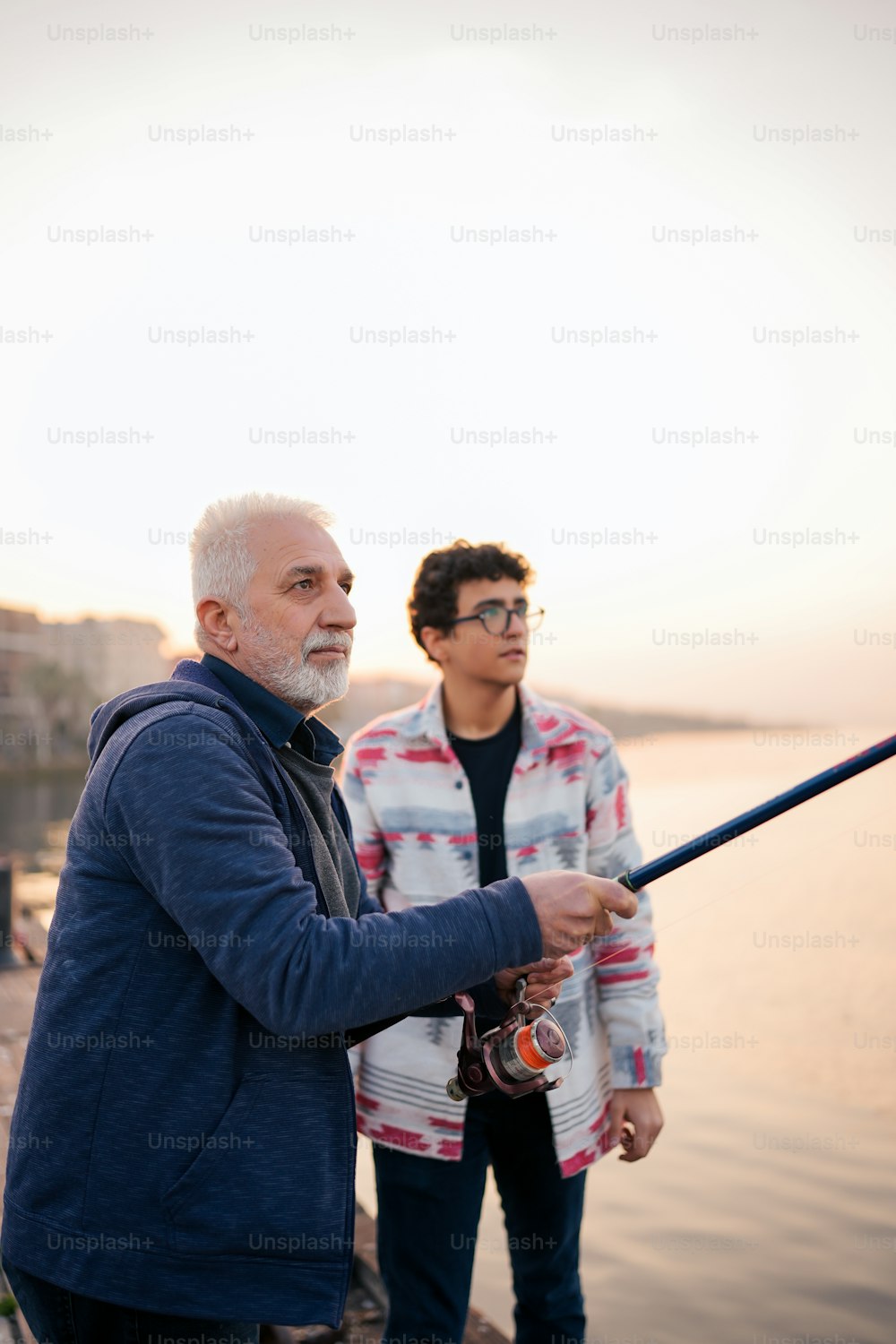 a man holding a fishing rod next to a woman