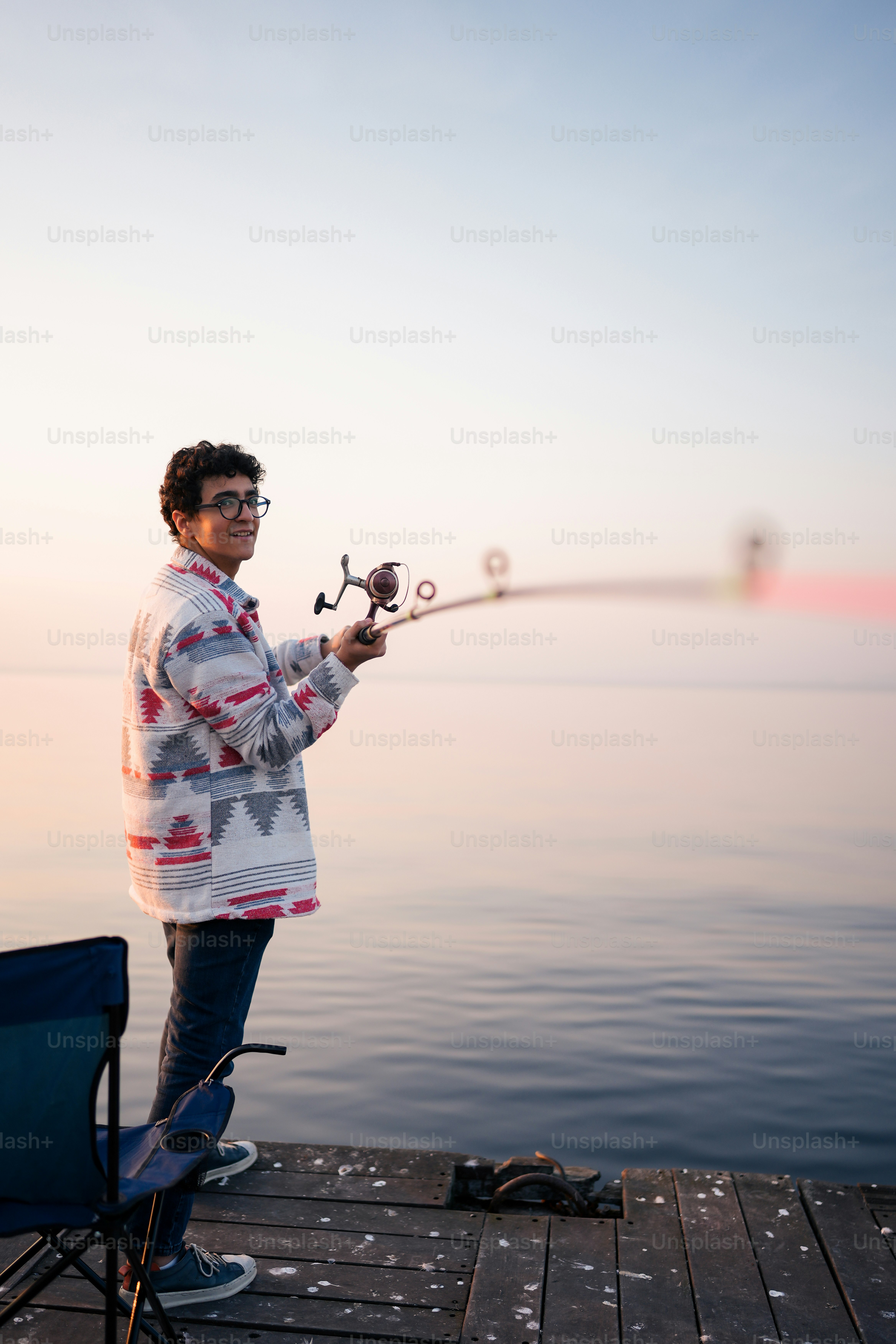 a man standing on a dock holding a fishing rod