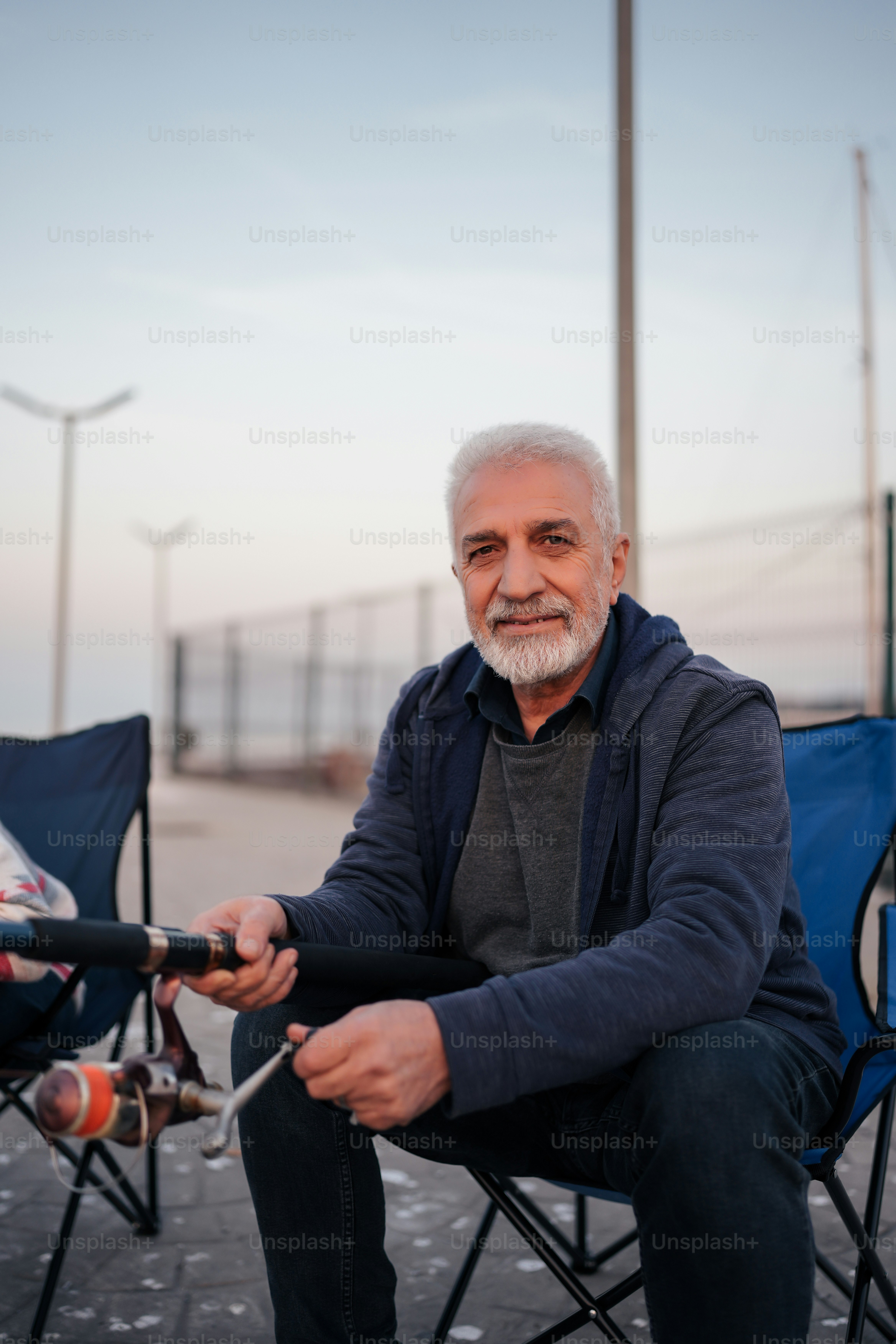 a man sitting in a chair holding a fishing rod