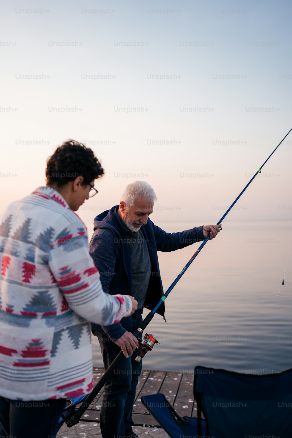 um homem e uma mulher pescando em uma doca