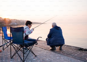 椅子に座って釣りをする男女