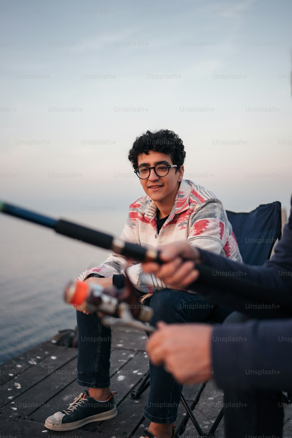 a man sitting on a chair holding a fishing rod