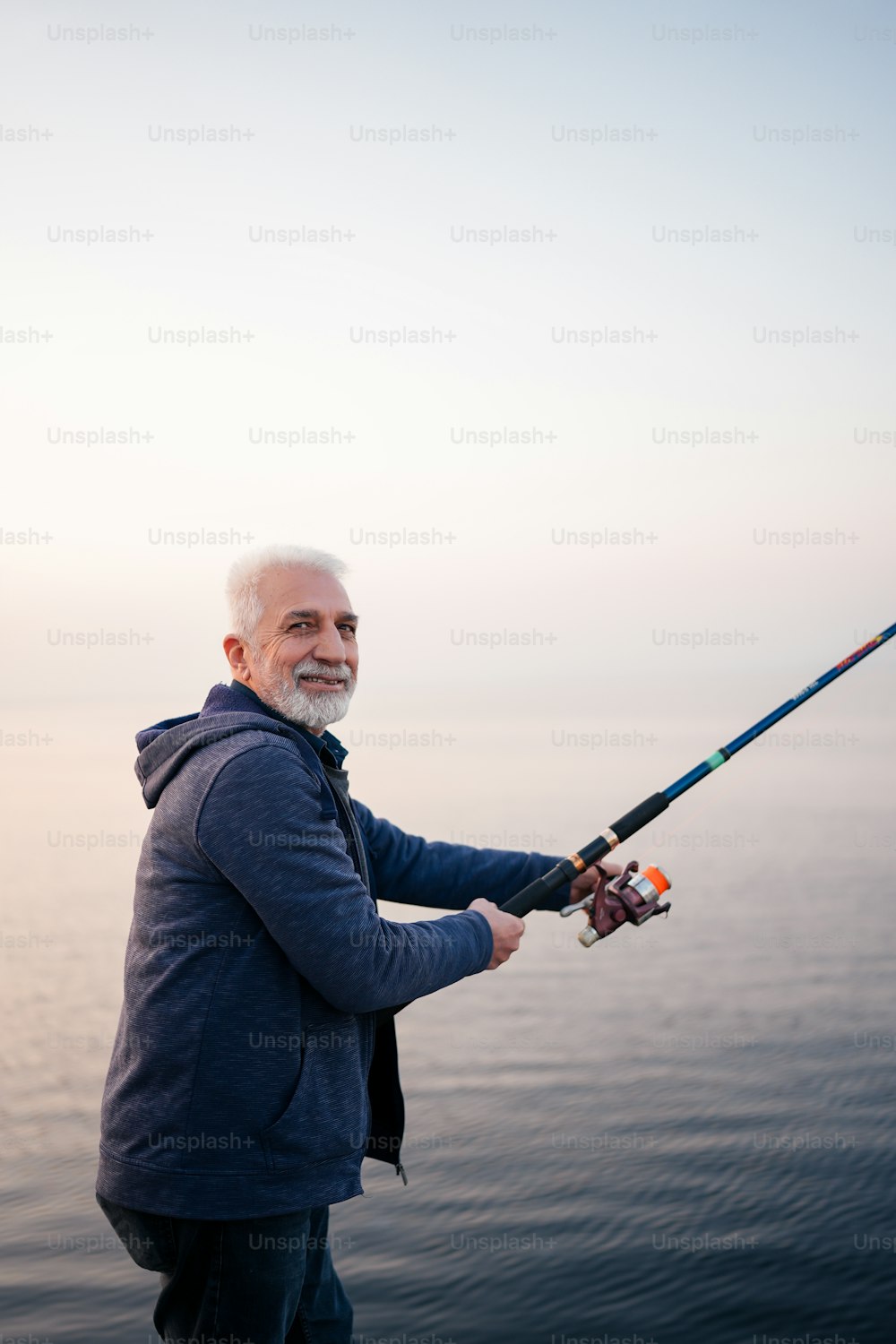 Ein Mann, der auf einem Boot steht und eine Angelrute hält