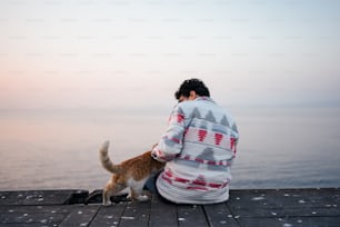 une personne assise sur un quai avec un chien