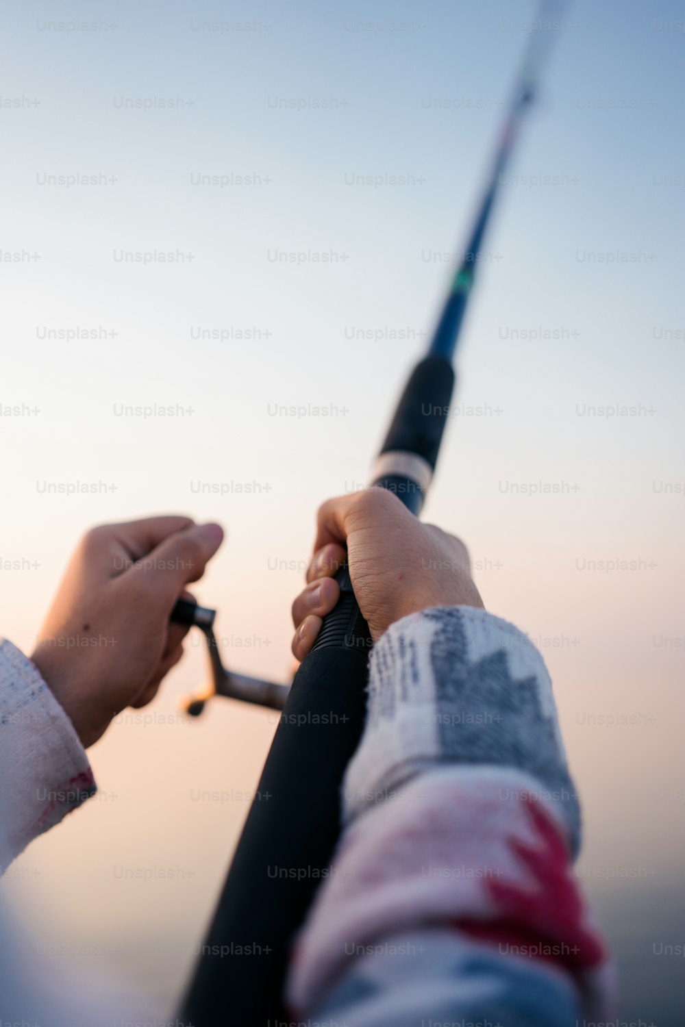 a person holding a fishing rod with a sky background
