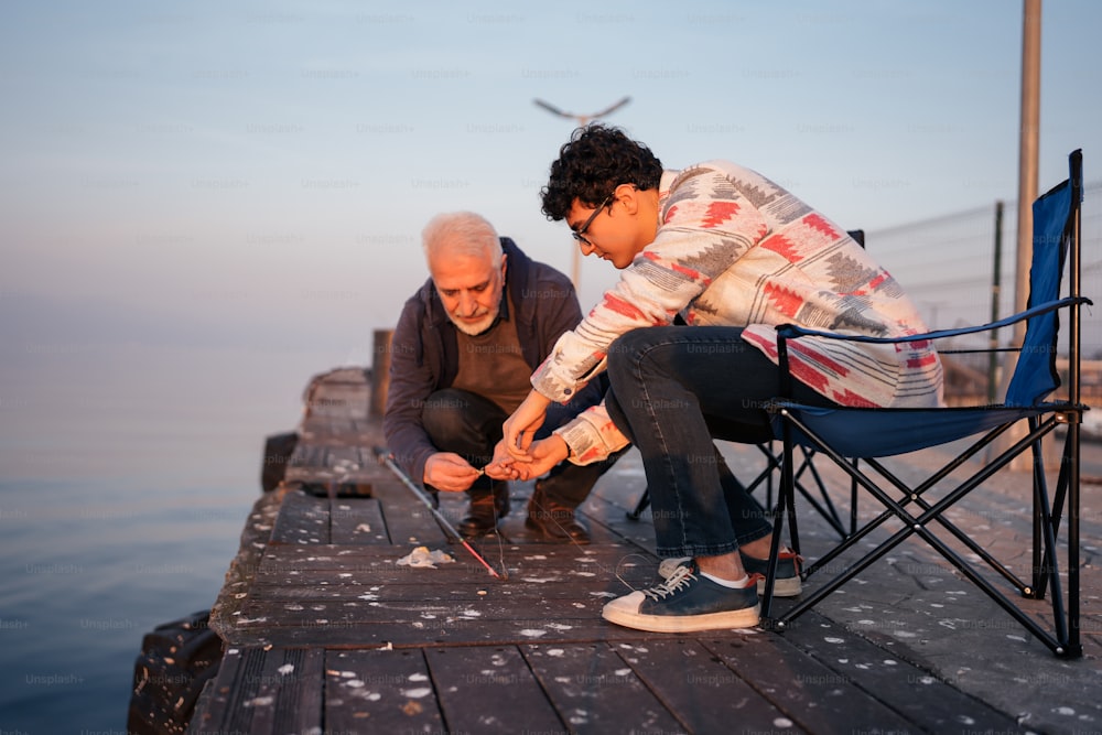 two men are on a dock with a fishing pole