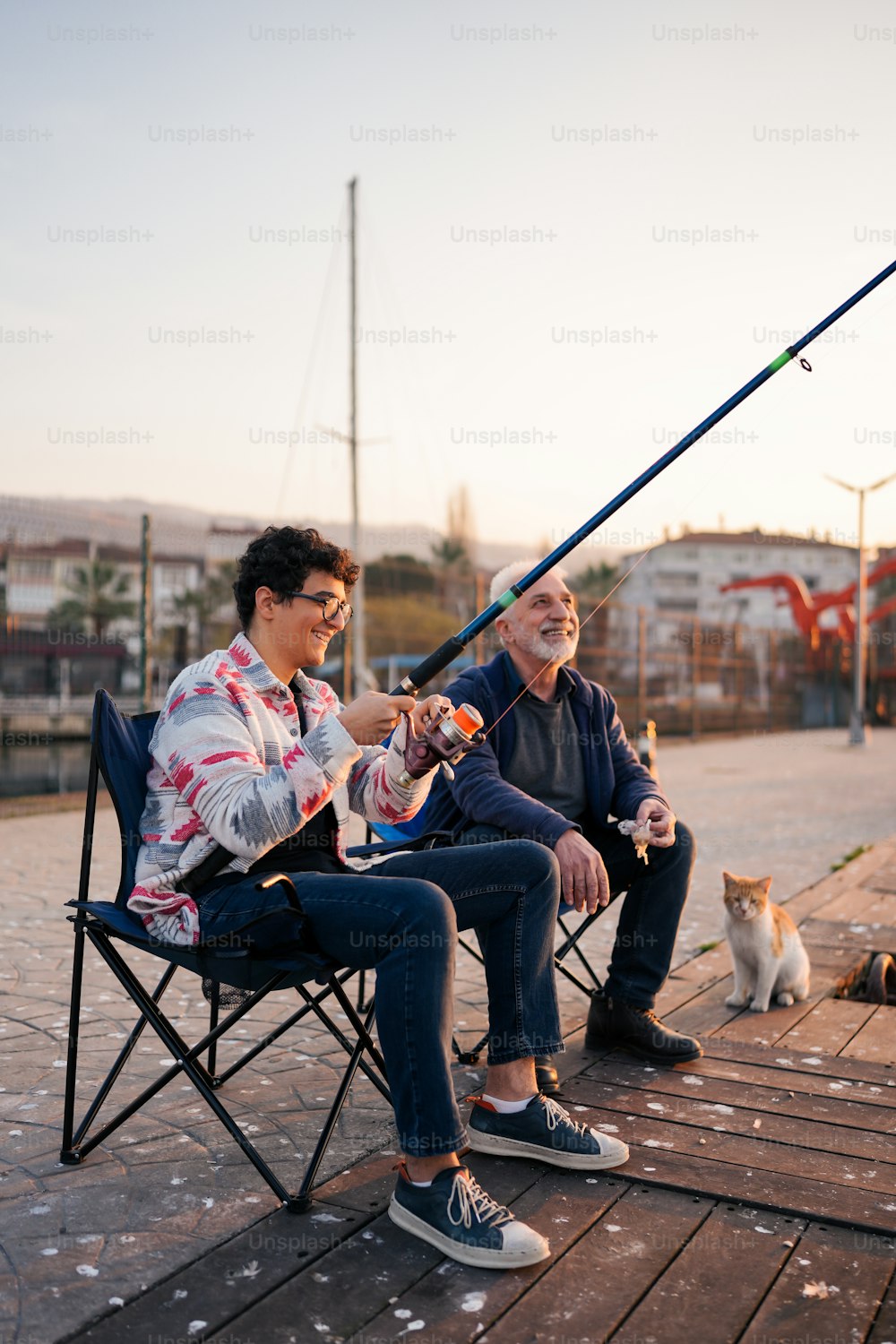 a man and a woman sitting on a chair with a fishing rod