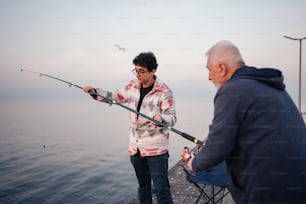 a man holding a fishing rod next to a woman