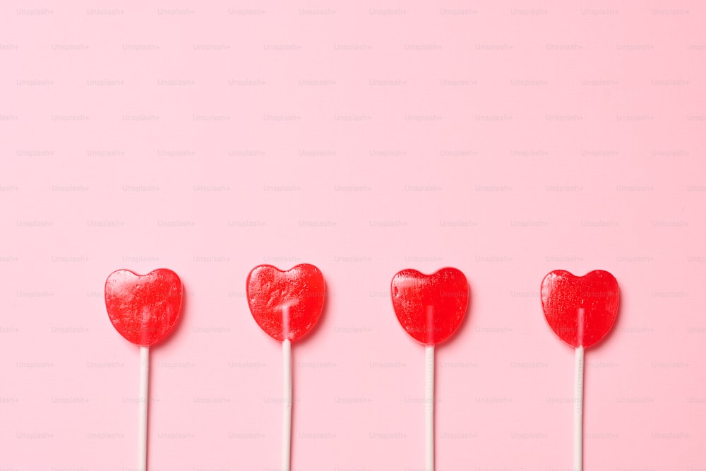 a row of heart shaped lollipops on a stick