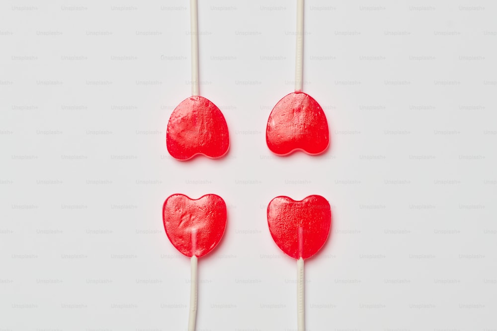 four heart shaped lollipops on a white background