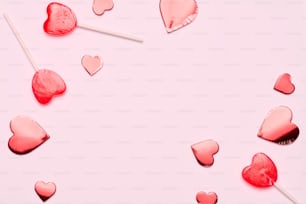 un gruppo di lecca-lecca a forma di cuore su uno sfondo rosa
