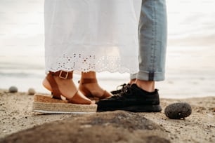 a couple standing next to each other on a beach
