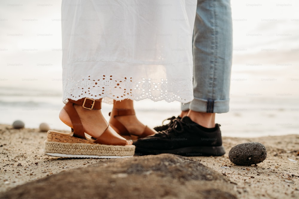 a couple standing next to each other on a beach